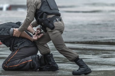 Polis suçlunun yakalanmasına yardım etti ve kelepçeleri taktı..