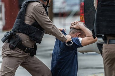 Polis suçlunun yakalanmasına yardım etti ve kelepçeleri taktı..