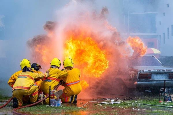 fireman using water and extinguisher car is on fire,Firefighter using extinguisher and water from hose for fire fighting,burning car Gas,Rescue Equipment.
