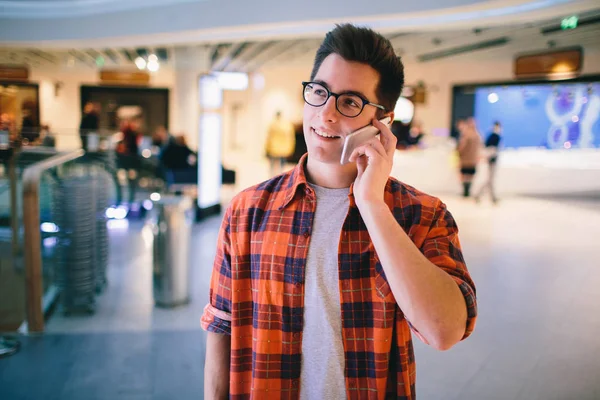 Homme tenir le smartphone sur fond de centre commercial — Photo