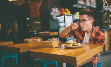Adam bir restoranda yemek yiyor ve lezzetli yemeklerin tadını çıkarıyor.