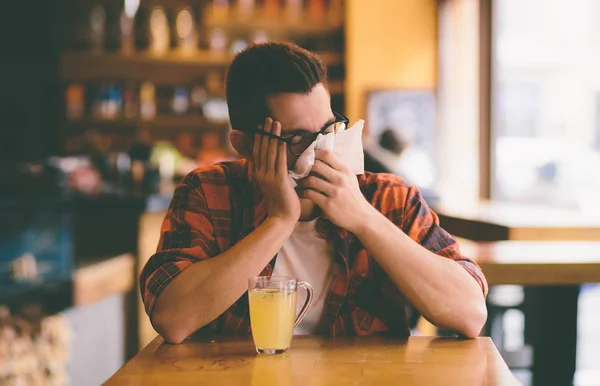 Sick student blowing his nose into a tissue — Stock Photo, Image