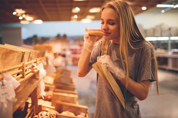 Jovem escolhe pão na loja — Fotografia de Stock