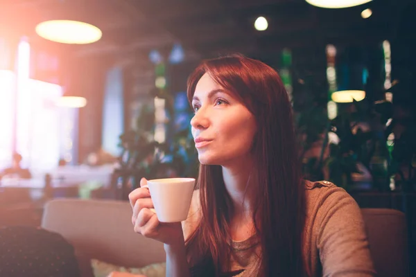 Heißen Becher Tee mit Frauenhänden. Schöne weibliche Tasse Kaffee auf dem Restaurnt. Mädchen mit roten Haaren — Stockfoto