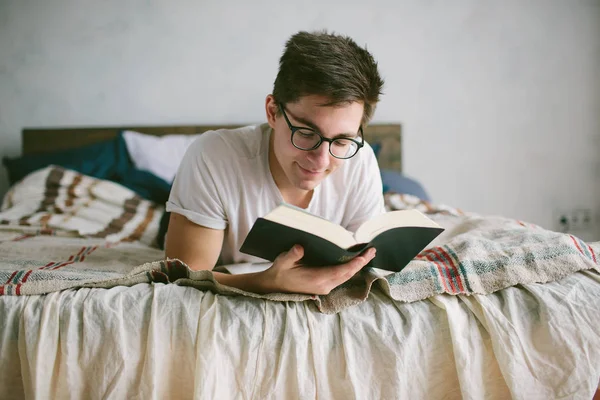Man reading a book on his bed at home — Stock Photo, Image