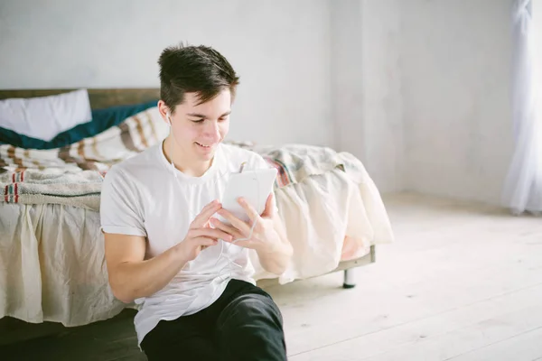 Handsome man surfing on tablet. Guy talking with friends, video conference, skype, tablet. The young student scrolls social networks — Stock Photo, Image