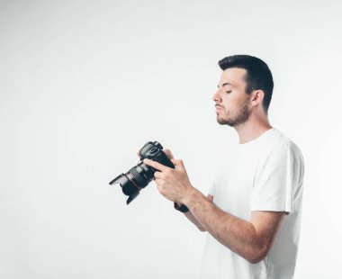 Seyahat, teknoloji ve yaşam tarzı konsepti: genç sakallı fotoğrafçı dijital kamerayla fotoğraf çekiyor.