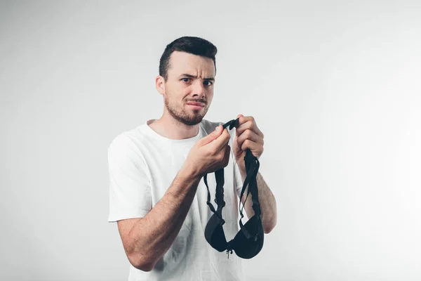 Ha un reggiseno da donna in mano. La moglie ha trovato suo marito con un'altra donna. Bustaltern padrona. Tracce di baci sul viso . — Foto Stock