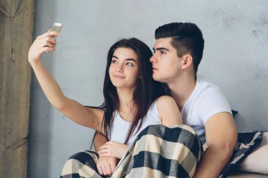 Erkek ve kadın evde selfie çekiyorlar.
