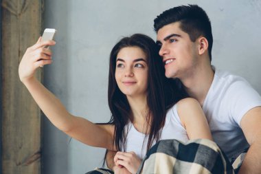 Erkek ve kadın evde selfie çekiyorlar.