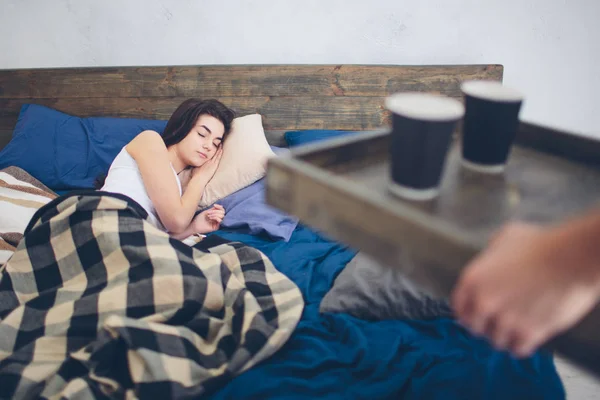 Seorang pemuda dan seorang wanita minum kopi di pagi hari di tempat tidur. Romantis pagi di rumah — Stok Foto