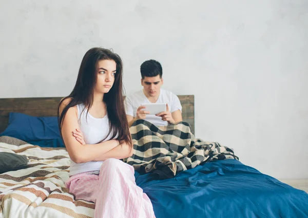 Family quarrel. The guy and the girl have strongly quarreled. The guy has a dependence on the smartphone — Stock Photo, Image