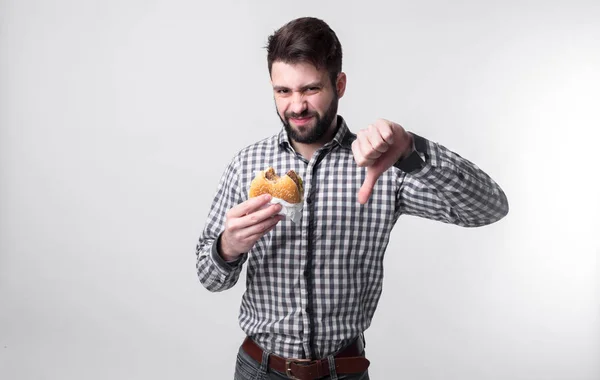 남자는 햄버거를 좋아하지 않아. 학생은 패스트 푸드를 먹는다. 도움이 안 음식. 매우 배고픈 사람 — 스톡 사진