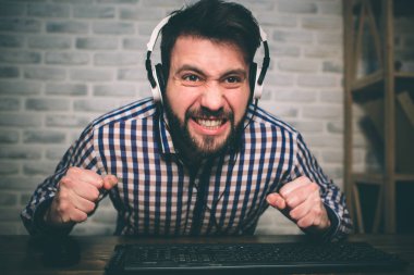 Evde oyun ve akışı sakallı adam. Komik adam nedeniyle görülen sanal video heyecanlı olduğunu. Kırmızı kulaklık takıyor