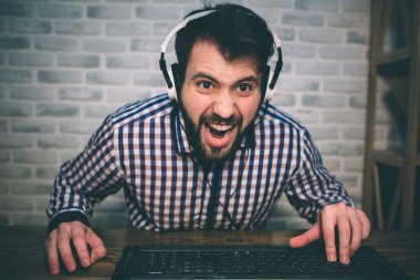 Evde oyun ve akışı sakallı adam. Komik adam nedeniyle görülen sanal video heyecanlı olduğunu. Kırmızı kulaklık takıyor