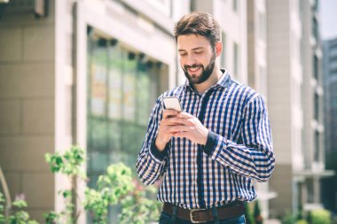 Yakışıklı sportif kahve içme ve telefonda konuşurken esmer adam sakallı