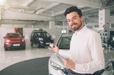yeni showroom arabalara sunmak kolay araç satıcısı. Genç erkek danışman gösteren yeni araba auto show fotoğraf. Kiralık Araba konsepti