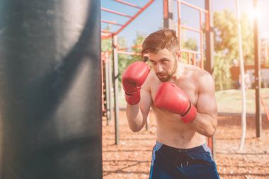Genç adam boks egzersiz. Boksör egzersiz spor boks konsepti. boksör yumruk el kum torbası ile