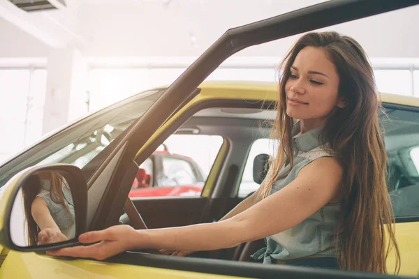 Zbliżenie portret szczęśliwy, uśmiechnięty, Młoda atrakcyjna kobieta, kupujący siedzi w jej nowy samochód na białym tle poza dealerem, dealerskiej wiele office. Osobisty transport, koncepcja zakupu auto — Zdjęcie stockowe