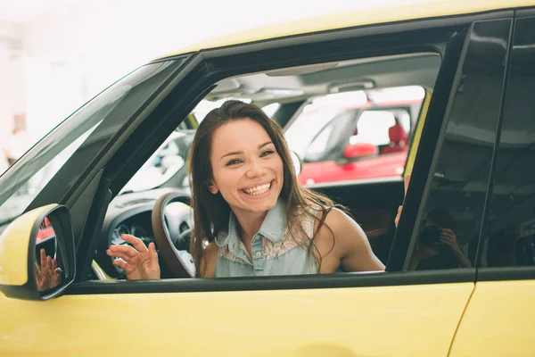 Närbild porträtt lycklig, leende, ung attraktiv kvinna, köparen som sitter i sin nya bil isolerade utanför återförsäljare, generalagenten hel office. Personlig transport, Köp AUTOCONCEPT — Stockfoto