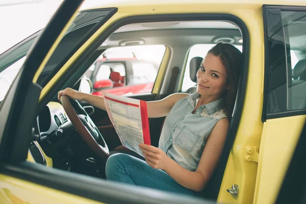 Gros portrait heureux, souriant, jeune femme attrayante, acheteur assis dans sa nouvelle voiture isolé concessionnaire extérieur, concessionnaire bureau lot. Transport personnel, concept d'achat auto — Photo