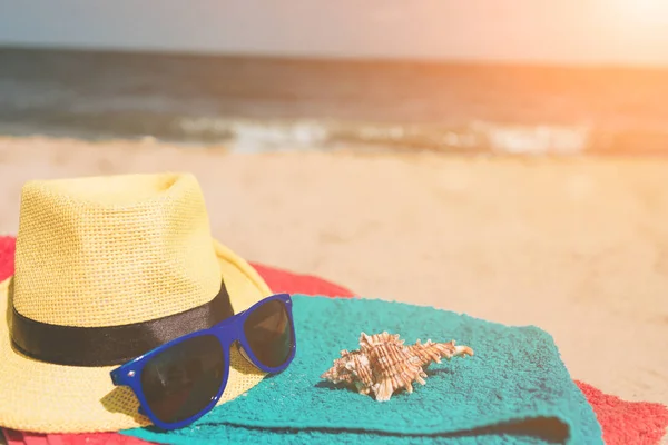 Havlu, güneş gözlüğü, kabuk, plaj kavramı üzerine şapka