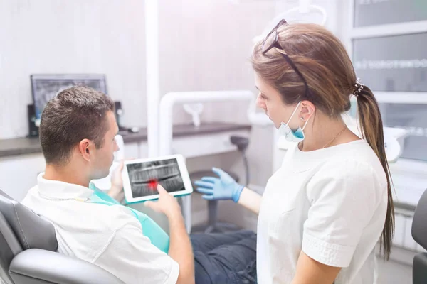 Portrait d'une dentiste et d'un jeune homme heureux dans un cabinet de dentiste. concept de technologie et de soins de santé - avec tablette PC — Photo