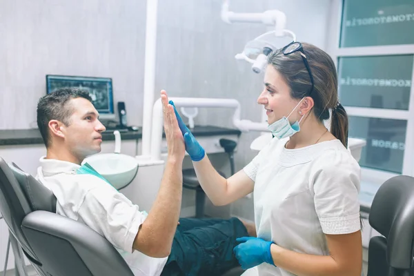 Portrait d'une dentiste et d'un jeune homme heureux dans un cabinet de dentiste. Homme ! — Photo