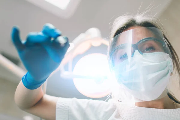 Retrato de dentista femenina. Ella examinando los dientes de un paciente  . — Foto de Stock