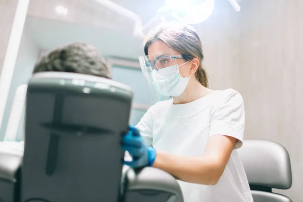 Retrato de dentista femenina. Ella examinando los dientes de un paciente  . — Foto de Stock