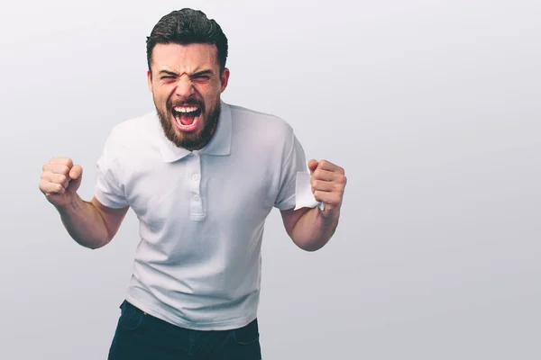 Portrait of a angry young man. He is clenches fists and shouts.. The wicked guy beats. — Stock Photo, Image