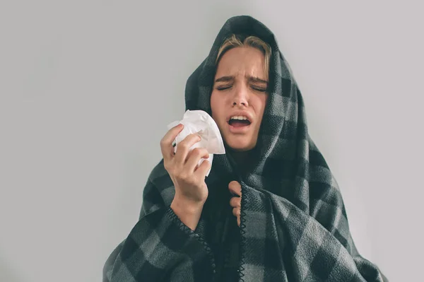 Imagen de estudio de una joven con pañuelo. La chica enferma aislada tiene secreción nasal. Modelo femenino hace una cura para el resfriado común . — Foto de Stock