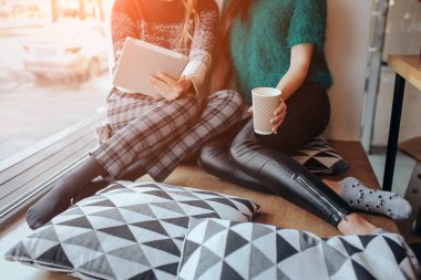 bir kafede chat yapan iki genç kadın. İki arkadaş birlikte kahve zevk. Bir kız bir tablet kullanır