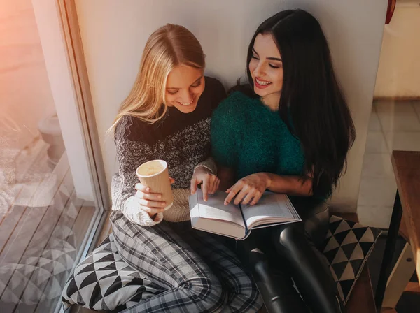 Kız kafede tatilinde kitap okuma emilir. Kitap okuma ve kahve içme şirin güzel genç kadın