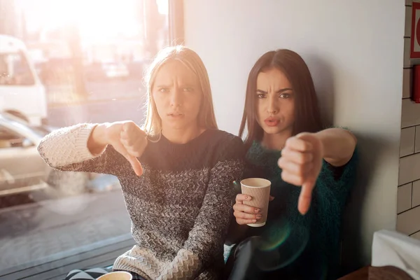 Vooraanzicht portret van twee grappige vrienden met duimen naar beneden en kijken naar de camera — Stockfoto