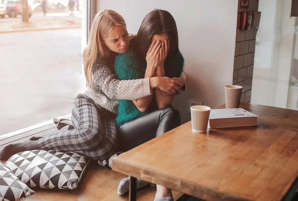 Onrustige jonge meisje getroost door haar vriend. Vrouw ter ondersteuning van het meisje — Stockfoto