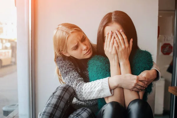 Beunruhigtes junges Mädchen, das von ihrem Freund getröstet wird. Frau unterstützt das Mädchen — Stockfoto