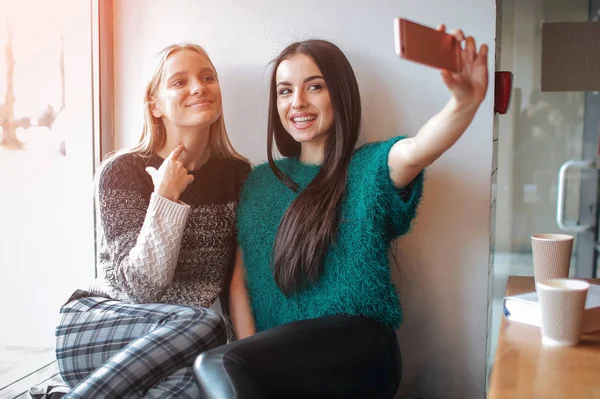 Glimlachend jonge vrouwen selfie te nemen terwijl het drinken van koffie binnenshuis bij lunch vergadering. — Stockfoto