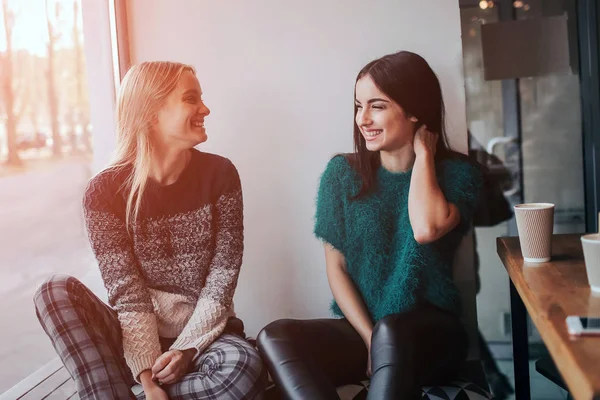 Twee jonge vrouw chatten in een koffieshop. Twee vrienden genieten van koffie samen. — Stockfoto