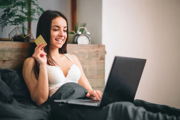 Mujer joven con tarjeta de crédito y el uso de ordenador portátil. Concepto de compras online — Foto de Stock