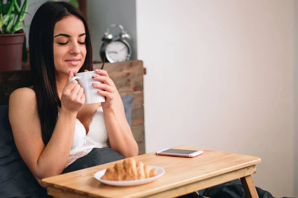 Ung vacker kvinna äter frukost på sängen — Stockfoto