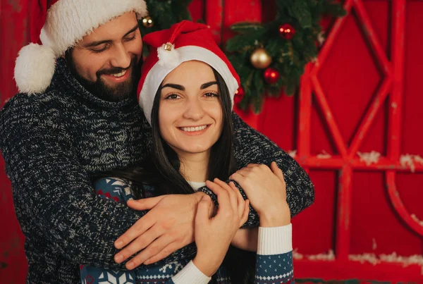 Frohe Weihnachten und ein gutes neues Jahr. junges Paar beim Urlaub zu Hause. glücklicher junger Mann und Frau umarmen und beschenken einander — Stockfoto
