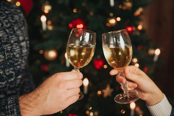 God jul och gott nytt år. Ungt par firar semester hemma. Cheers närbild foto, man och kvinna anläggning glas champagne på xmas. — Stockfoto