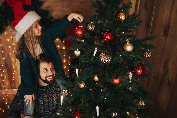 Feliz padre y su hijita decorando el árbol de Navidad en casa. — Foto de Stock