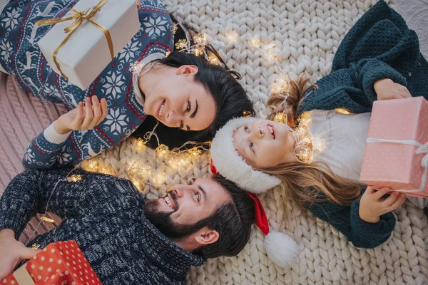 Frohe Weihnachten und frohe Feiertage, fröhliche Mutter, Vater und ihre süße Tochter tauschen Geschenke aus. Eltern und kleine Kinder vergnügen sich in der Nähe des Weihnachtsbaums im Haus. Weihnachten am Morgen. Porträt Familie — Stockfoto