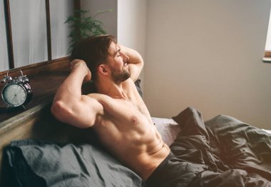 Kaygısız adam zevk yeni gün. Seksi, mutlu sakallı adam yatakta