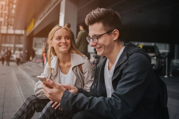 Paar oder Freunde lachen lustig und haben Spaß mit einem Smartphone in einer Großstadt Straße. — Stockfoto