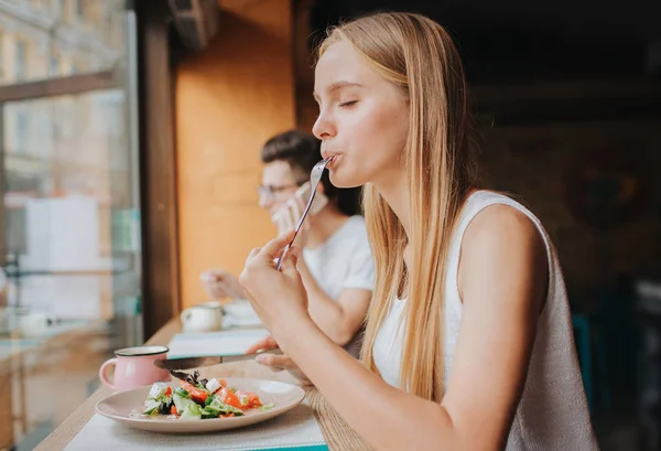 Portret van een aantrekkelijke blanke lachende vrouw die salade eet — Stockfoto