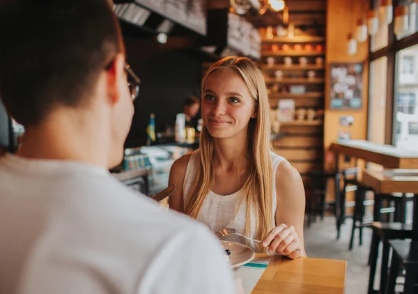 Gelukkige jonge paar in liefde met een mooie datum in een bar of restaurant. Zij sommige verhalen te vertellen over zichzelf, thee of koffie drinken en en eten salade en soep — Stockfoto