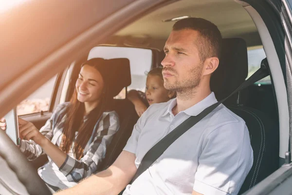 Familia feliz en un viaje por carretera en su coche. Papá, mamá e hija están viajando por el mar o el océano o el río. Paseo de verano en automóvil — Foto de Stock